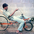 An associate tries out a modified bicycle design built by Ray Wijewardene to improve speed and reduce effort for the rider. Circa 1985.

